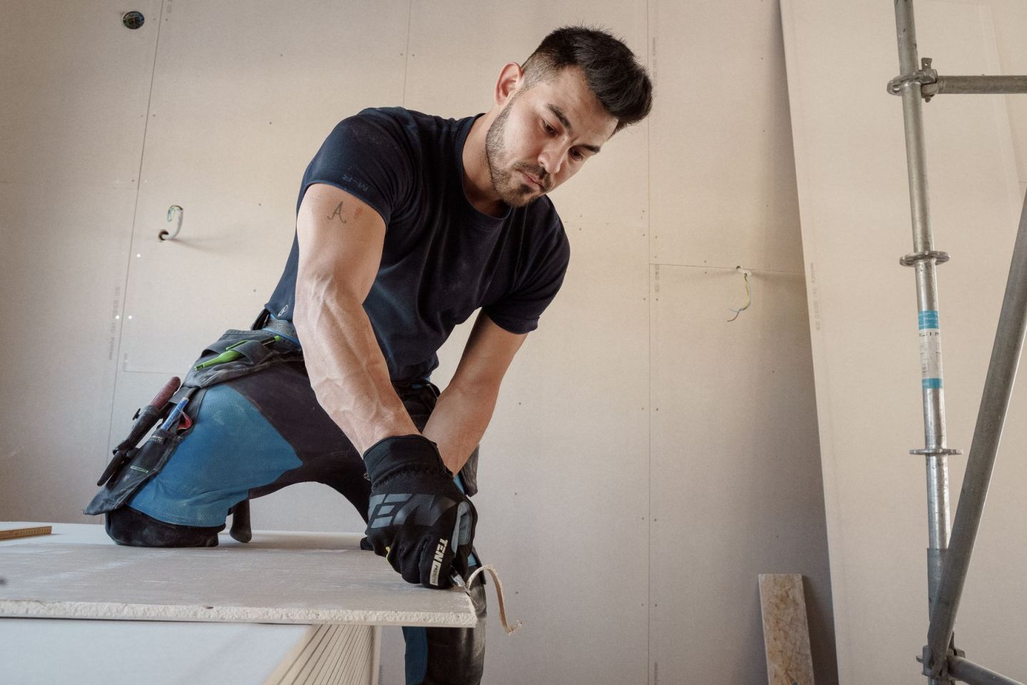 Zuschnitt einer Gipsplatte auf dem Plattenstapel vor der Montage an der Decke