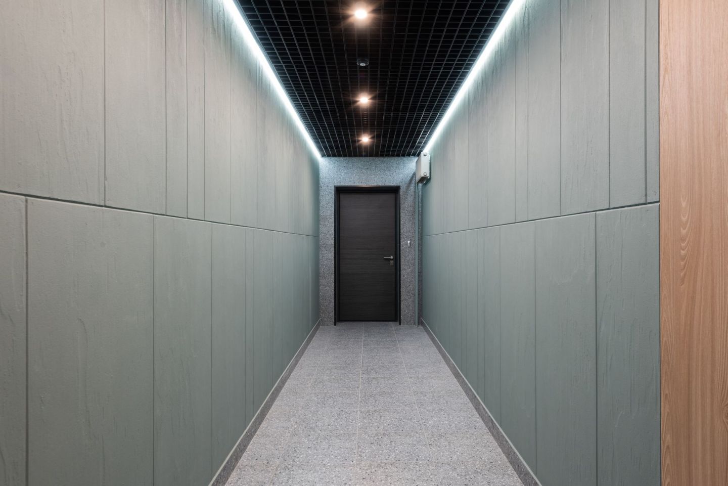 Flur mit abgehängter Rasterdecke und umlaufender Lichtvoute